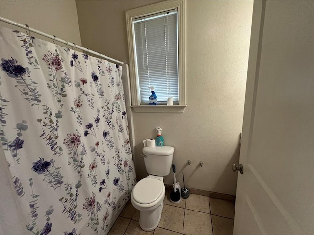 bathroom with a shower with curtain, tile patterned flooring, and toilet