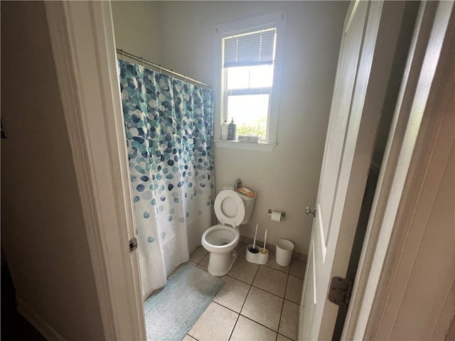 bathroom featuring tile patterned floors, toilet, and a shower with curtain