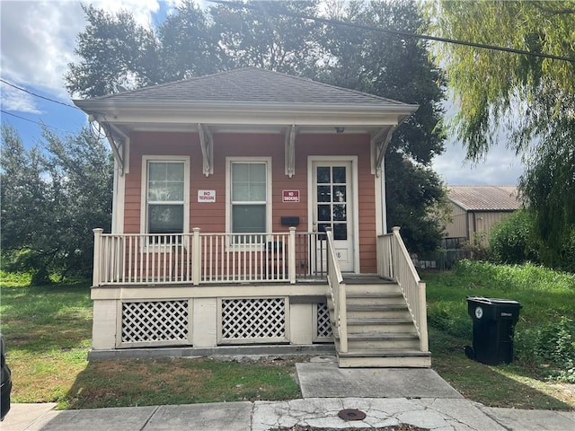 bungalow-style house featuring a front yard and covered porch