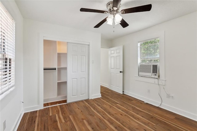 unfurnished bedroom featuring a closet, hardwood / wood-style floors, cooling unit, and ceiling fan