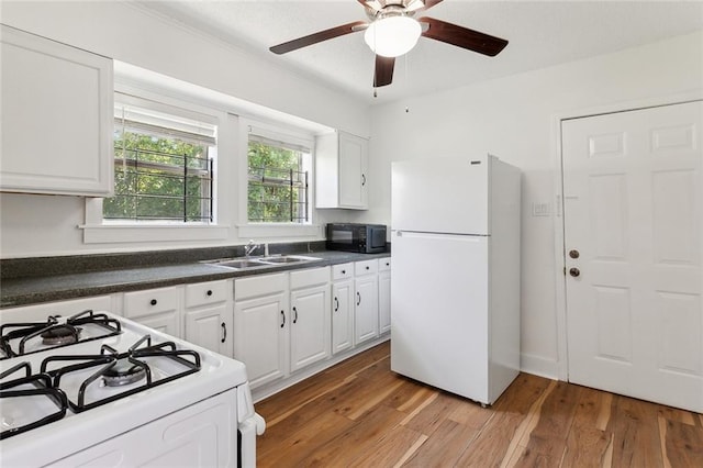 kitchen with light wood-type flooring, ceiling fan, white appliances, sink, and white cabinetry