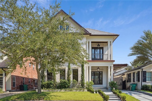 view of front facade featuring a balcony and a front lawn