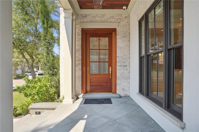 view of exterior entry featuring covered porch and stone siding