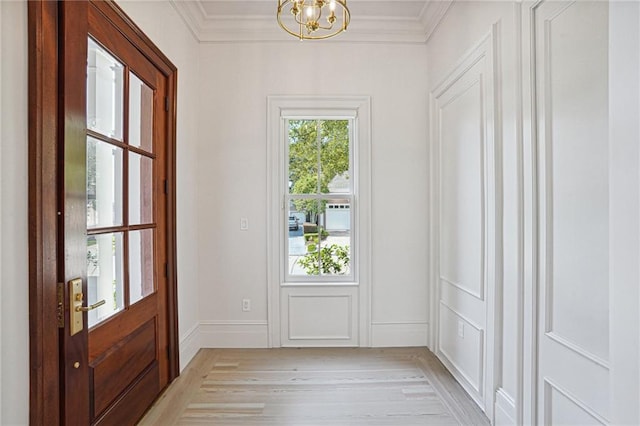 doorway to outside featuring a notable chandelier, crown molding, light wood-style flooring, and baseboards