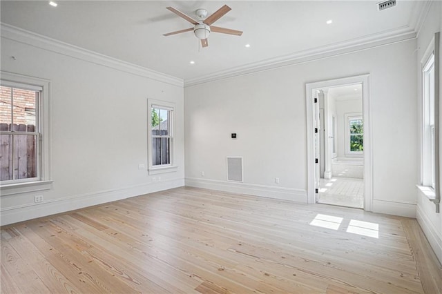 unfurnished room featuring light wood-type flooring, ornamental molding, plenty of natural light, and visible vents