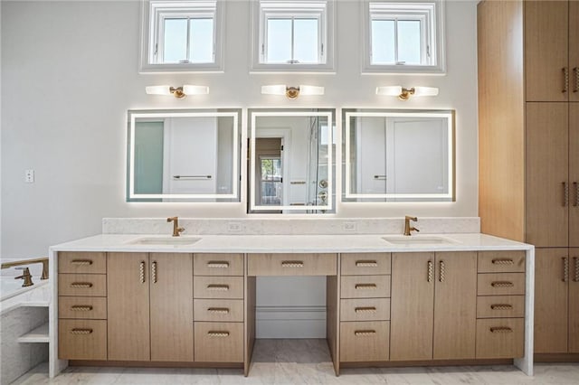 bathroom featuring double vanity, marble finish floor, and a sink