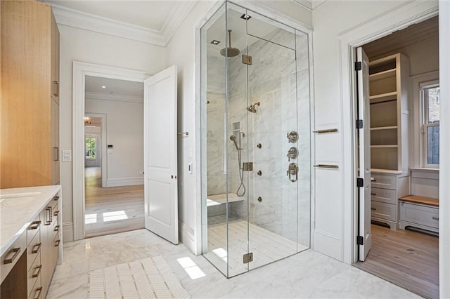 full bath featuring marble finish floor, a shower stall, ornamental molding, and vanity