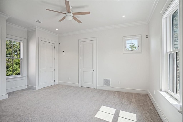 unfurnished bedroom with light carpet, ornamental molding, and ceiling fan