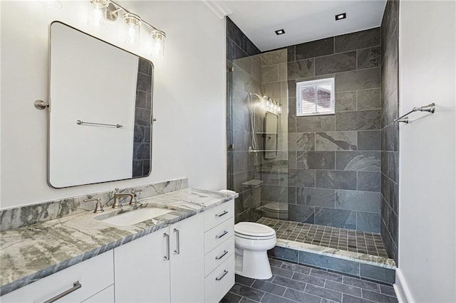 bathroom featuring toilet, tile patterned floors, a walk in shower, and vanity