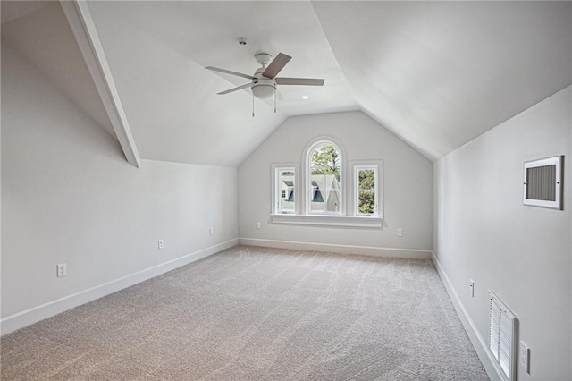 additional living space featuring light carpet, a ceiling fan, visible vents, vaulted ceiling, and baseboards