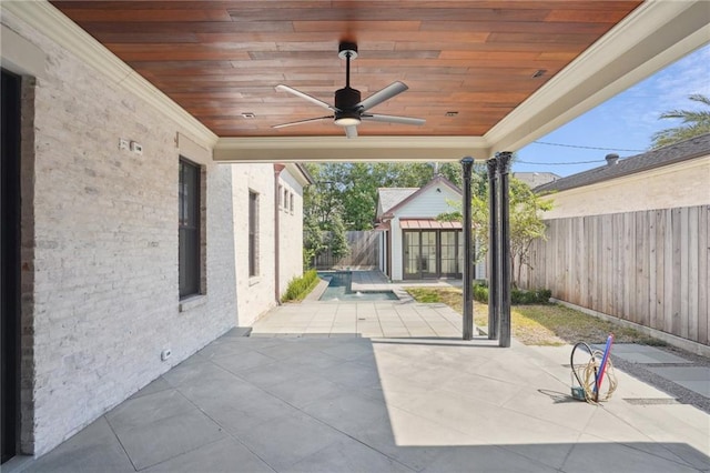 view of patio / terrace featuring an outbuilding, a fenced backyard, and a ceiling fan