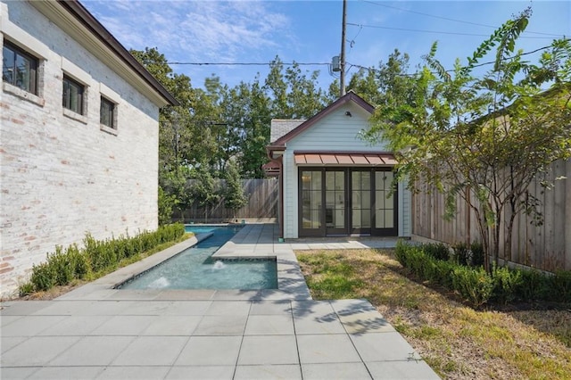 view of swimming pool with french doors and a patio area