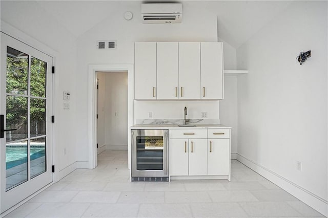 bar with wine cooler, visible vents, vaulted ceiling, a sink, and baseboards