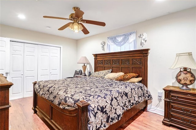 bedroom with ceiling fan, light hardwood / wood-style flooring, and a closet