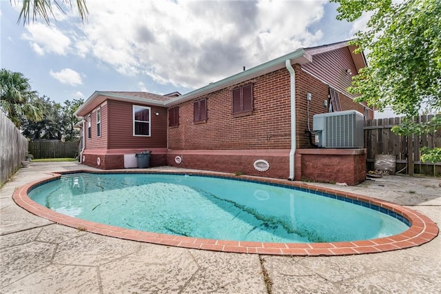 view of pool with cooling unit and a patio