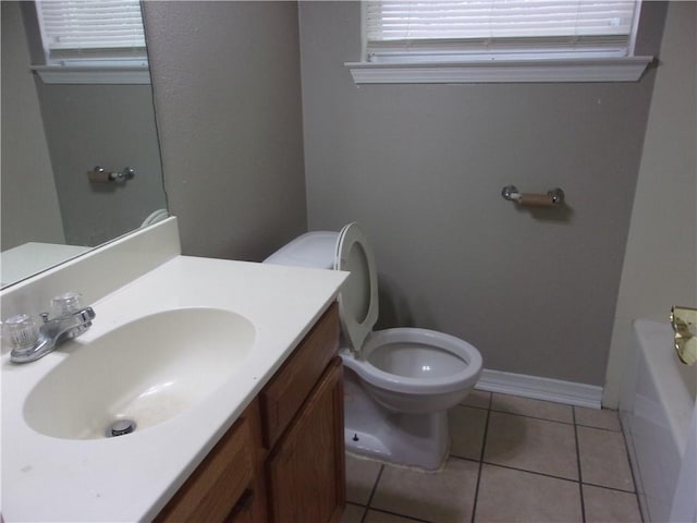 bathroom featuring a tub, tile patterned floors, vanity, and toilet