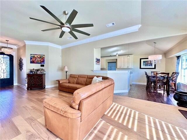 living room with ornamental molding, ceiling fan with notable chandelier, and hardwood / wood-style flooring