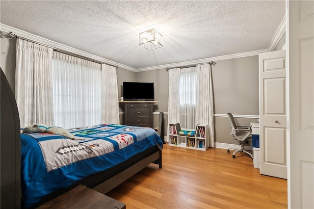 bedroom with crown molding, wood-type flooring, and a textured ceiling