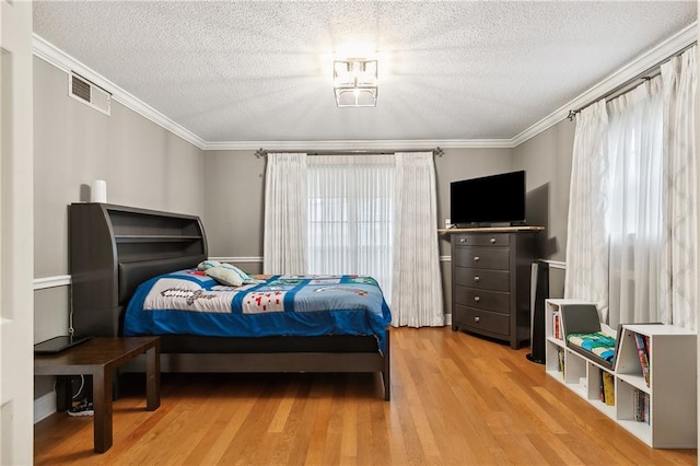 bedroom with crown molding, hardwood / wood-style floors, and a textured ceiling