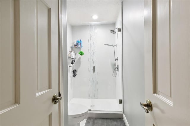 bathroom with toilet and an enclosed shower