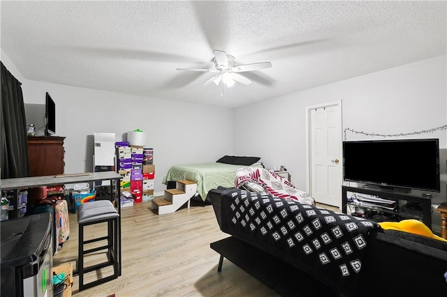 bedroom featuring a textured ceiling, light wood-type flooring, and ceiling fan