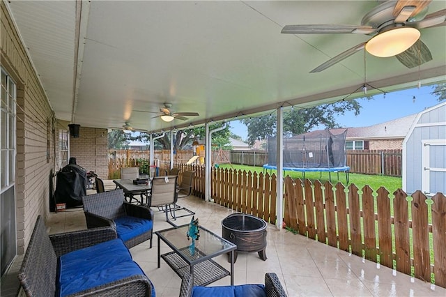 exterior space featuring a trampoline, a storage unit, and ceiling fan