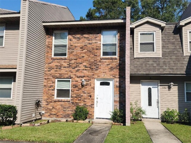 336 Indian Village Rd Unit 7, Slidell, LA 70461 - townhome / multi-family property featuring brick siding, a front yard, and a shingled roof