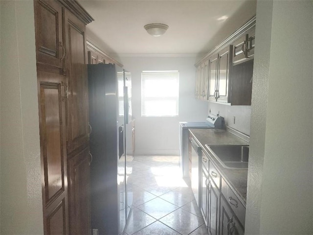 kitchen with light tile patterned floors, dark brown cabinets, and sink