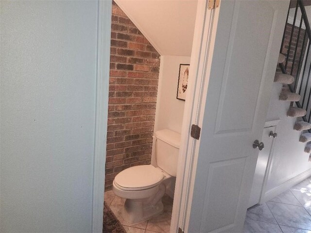336 Indian Village Rd Unit 7, Slidell, LA 70461 - bathroom featuring brick wall, toilet, and lofted ceiling