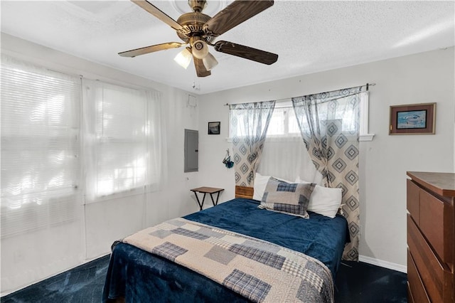 bedroom featuring electric panel, dark carpet, a textured ceiling, and ceiling fan