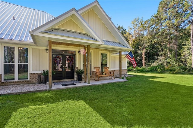 property entrance with french doors and a lawn