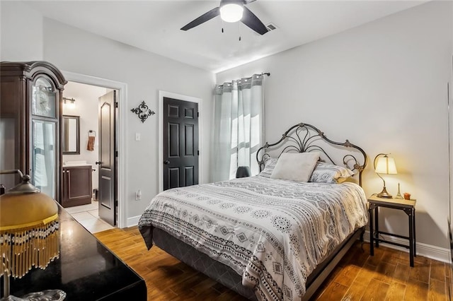 bedroom with ceiling fan, ensuite bath, and hardwood / wood-style floors