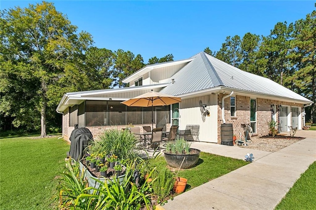 view of home's exterior featuring a yard, a sunroom, and a patio area