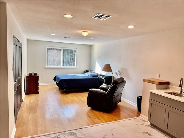 bedroom with light hardwood / wood-style flooring and sink