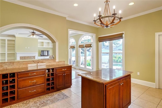 kitchen with a kitchen island, light stone countertops, pendant lighting, and light tile patterned floors