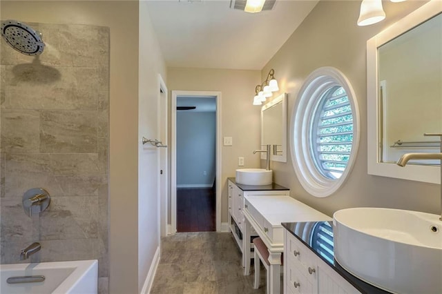 bathroom with vanity and tiled shower / bath combo