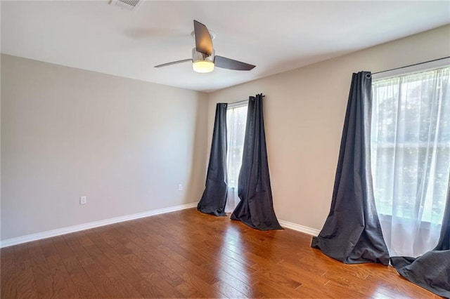 spare room with hardwood / wood-style flooring, a healthy amount of sunlight, and ceiling fan