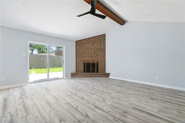 unfurnished living room featuring vaulted ceiling with beams, light wood-type flooring, and a brick fireplace