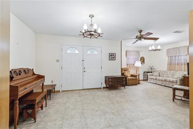 foyer entrance featuring ceiling fan with notable chandelier