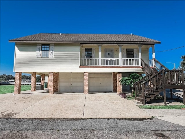 view of front of property with a porch, concrete driveway, stairway, an attached garage, and a carport