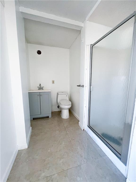 bathroom featuring vanity, toilet, and an enclosed shower