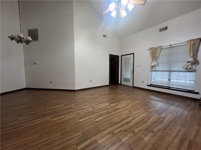 unfurnished room featuring ceiling fan with notable chandelier, high vaulted ceiling, and dark hardwood / wood-style floors