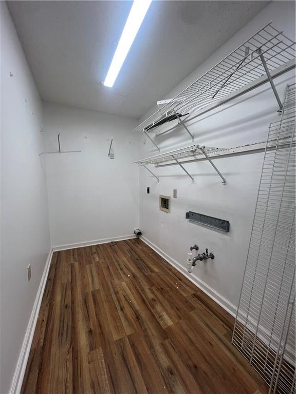 laundry room with hookup for a washing machine, dark hardwood / wood-style floors, hookup for a gas dryer, and electric dryer hookup