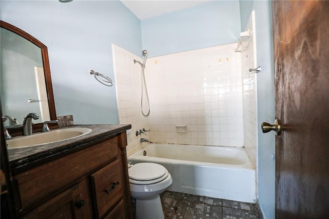 full bathroom with tiled shower / bath, vanity, and toilet