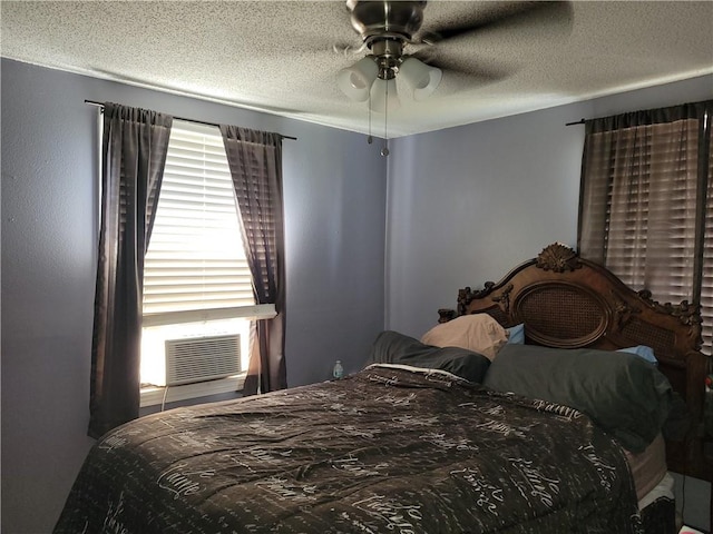 bedroom featuring cooling unit, a textured ceiling, and ceiling fan