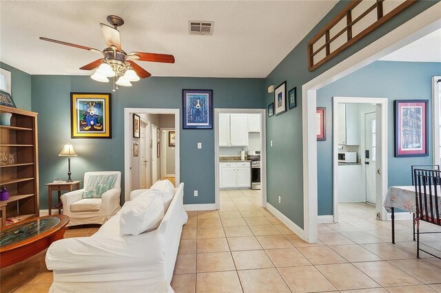 living room with ceiling fan and light tile patterned flooring