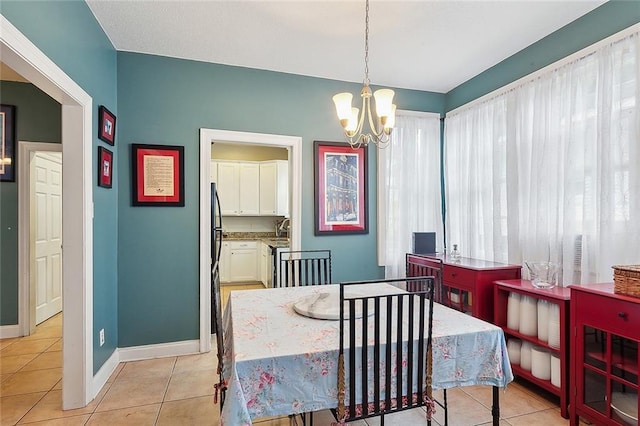 dining space featuring a notable chandelier, light tile patterned floors, and baseboards