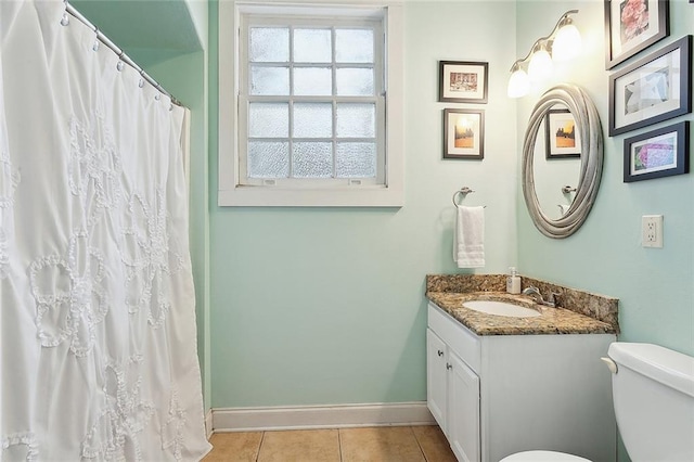 bathroom featuring tile patterned floors, toilet, vanity, and baseboards