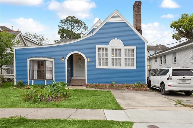 view of front of home featuring a chimney and a front yard