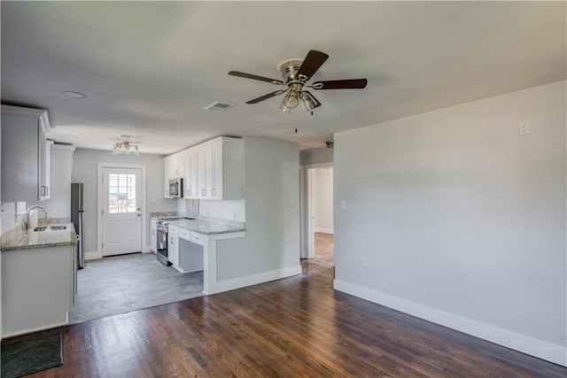 kitchen featuring ceiling fan, white cabinets, stainless steel appliances, and dark hardwood / wood-style flooring